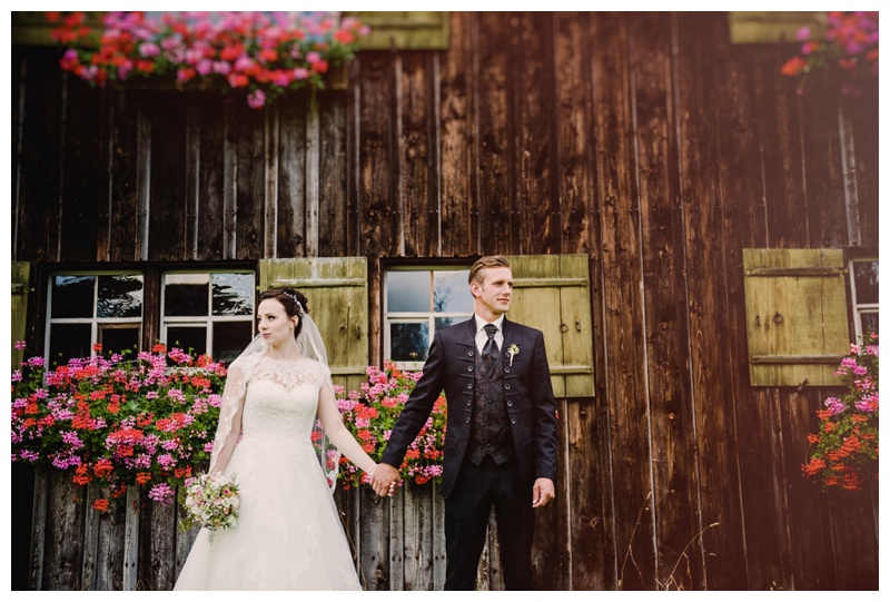 Brautpaar vor Holzgebäude- Hochzeitsfotograf in Illerbeuren